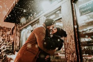 A couple about to kiss under the snowfall in Switzerland