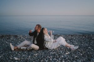 A couple enjoying a drink at the beach.