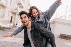 A girl in the arms of her partner, smiling.